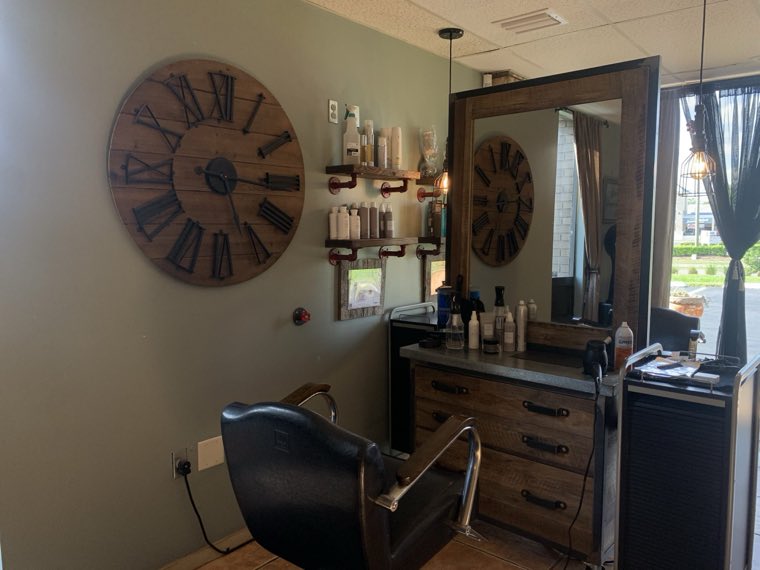 Wall of shelved products beside a styling chair